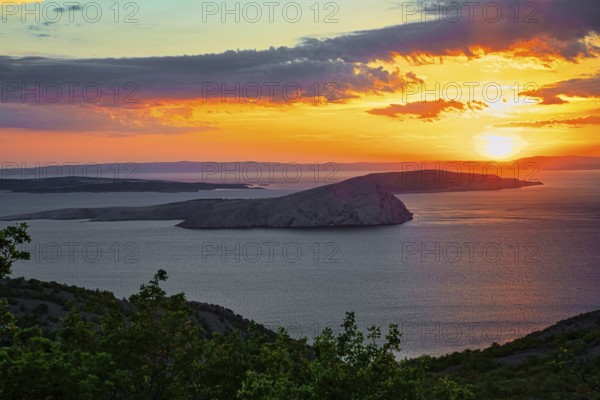 A calm sunset over the sea with an island in the foreground and colourful clouds in the sky, Mediterranean Sea, Coast, Dalmatia, Croatia