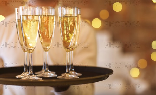 Champagne glasses on tray in bright lights. Party or celebration