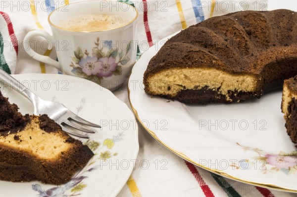 Slice of marbled cake on a plate with a cup of coffee on a coloring background