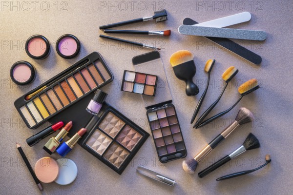 Cosmetics makeup lipstick eye shadows arrangement on glitter silver table