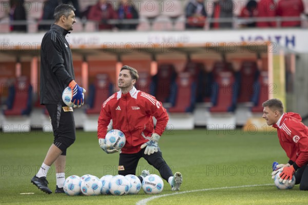 Football match, goalkeeper coach Michael Gspurning 1. FC Union Berlin left with goalkeeper Carl KLAUS 1.FC Union Berlin centre with ball looking towards him left and Alexander SCHWOLOW 1. FC Union Berlin right warming up in front of the match, Voith-Arena, Heidenheim, Germany