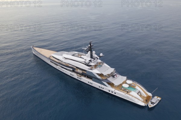 Aerial view of 109 metre motor yacht Bravo Eugenia, delivered in 2018 by the Dutch shipyard Oceanco to owner Jerry Jones, at anchor off the Principality of Monaco, behind Roquebrune Cap Martin, France, Cote d'Azur, Mediterranean Sea