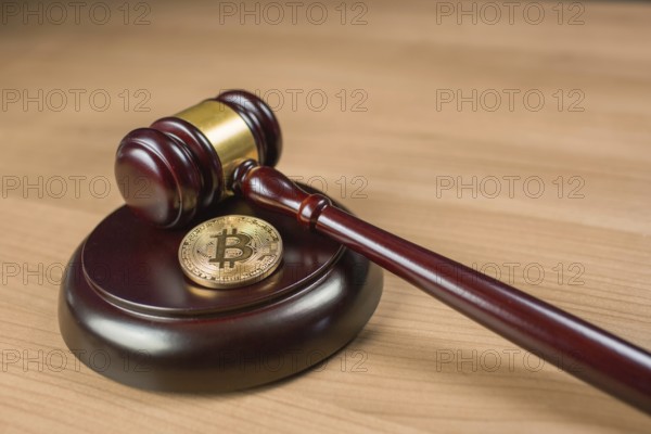 Bitcoin regulation. BTC cryptocurrency coin and judge gavel on a desk. Banned currency or law enforcement concept