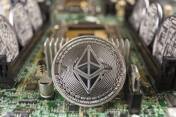 Ethereum coin close-up on a computer circuit motherboard as a blockchain technology payment network. Digital cryptocurrency concept and mining