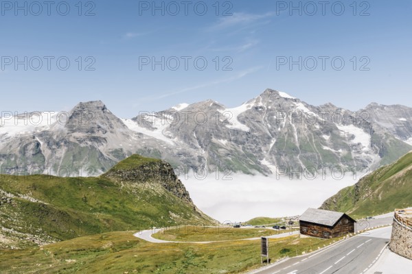 Scenic view of Alpine road through valley with sea of clouds. Grossglockner, Austria. Space for copy