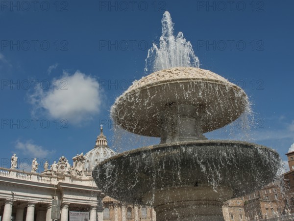 An impressive fountain in the centre of an ancient architectural setting under a clear blue sky, Rome, Italy
