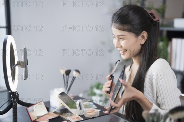 Beauty blogger Young Asian girl makeup artist Professional Woman blogger vlogger is showing cosmetics products with recording video Beauty influencer asian girl video online marketing live streaming