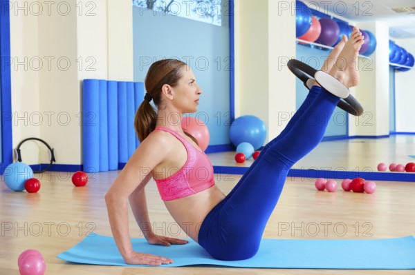 Pilates woman hip twist magic ring exercise workout at gym indoor