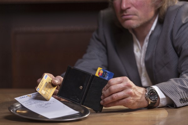 Man in suit pays the bill with credit card, Mindelheim, Bavaria, Germany
