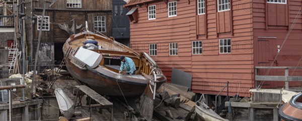 Spakenburg, The Netherlands - Fedbruary 19, 2021: Man inspecting historic ship at wooden ship wharf in the little pictoresque fishing village Spakenburg Bunschoten in Utrecht in the Netherlands, Bunschoten, Nederland