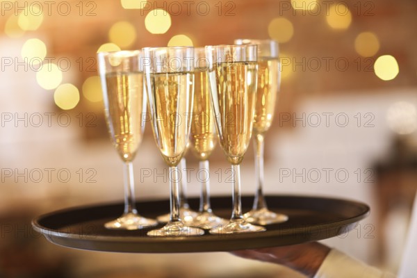 Champagne glasses on tray in bright lights. Party or celebration