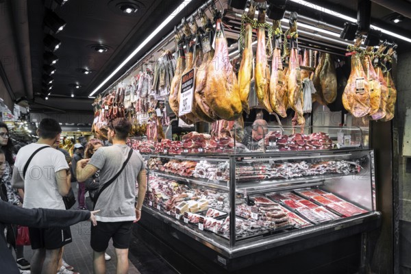 Chorizo and jamon serrano stalls at famous la boqueria market in barcelona spain