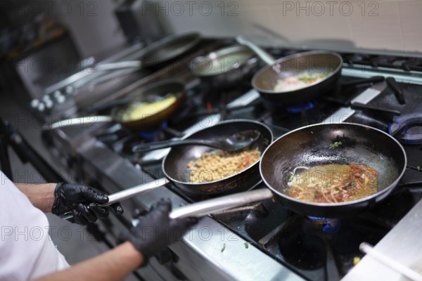 Chef cooking with various ingredients in pans on a stove