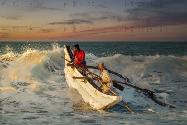 Sri Lankan fishermen breaking the wave at Kahandamodara Beach, Sri Lanka