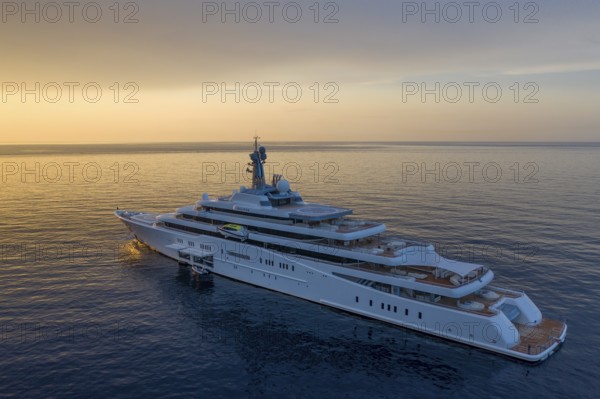 Aerial view 162, 5 metre long motor yacht ECLIPSE, delivered in 2010 by the Hamburg shipyard Blohm & Voss to the Russian oligarch Roman Abramovich, designer Terence Disdale, until 2013 the largest yacht in the world, at anchor at sunrise in the bay of Beaulieu-sur-Mer near Cap Ferrat, French Riviera, France, Mediterranean Sea