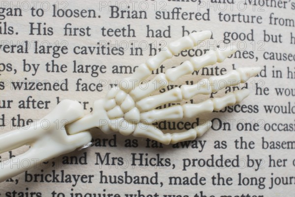 Skeletal hands book text. death, halloween and mistery concept
