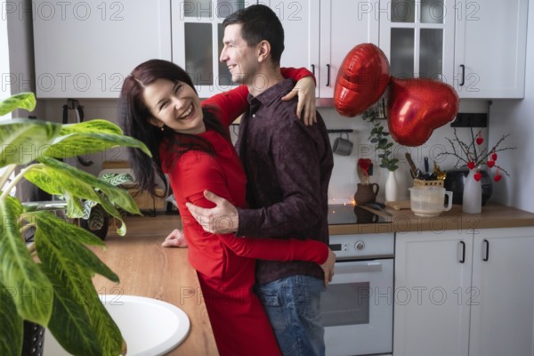 Man and woman in love date at home in kitchen happy hugs. Valentine's Day, happy couple, love story. Love nest, housing for young family