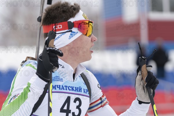 Portrait Russian sportsman biathlete Zlobin Vladislav Khanty-Mansiysk at finish after rifle shooting and skiing. Junior biathlon competitions East of Cup. Kamchatka, Russian Far East, April 12, 2019