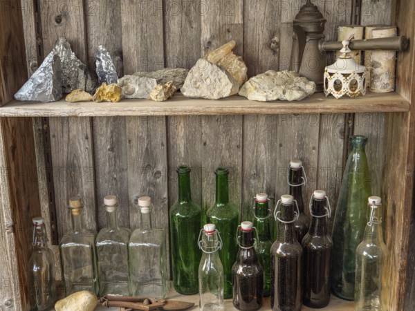 Shelves with bottles and stones on a rustic wooden wall, antique atmosphere, borken, münsterland, germany