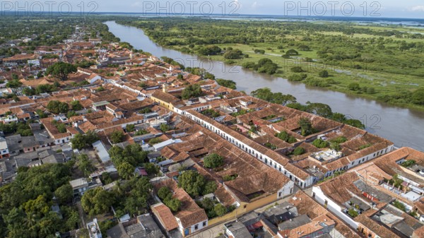 Aerial view of the historic town Santa Cruz de Mompox in sunlight with river and green sourrounding, World Heritage