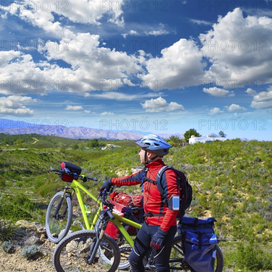 Cycling tourist MTB cyclist in Pedralba Valencia with paniers and saddlebag Spain