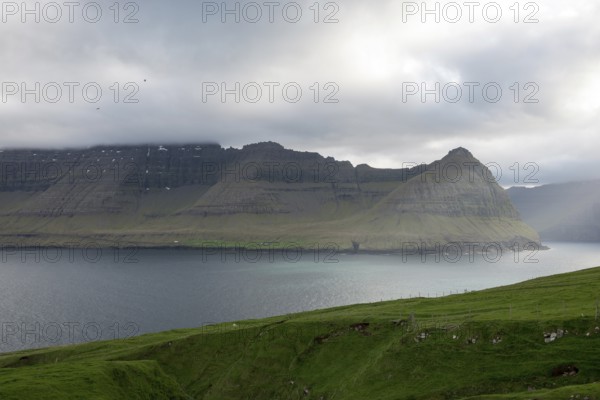 Typical landscape on the Faroe Islands, with green grass and rocks as seen from Vidareidi, Vidareidi, Faroe Islands