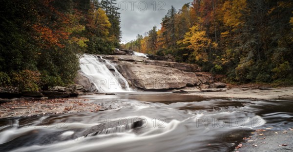 Triple Falls waterfall in fall color forest in the Appalachian mountains of North Carolina
