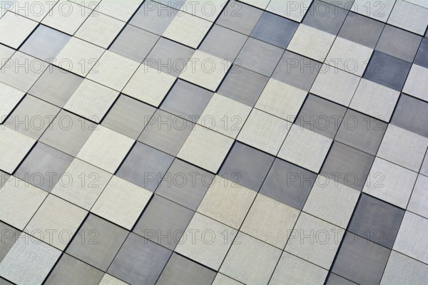 Detail of the façade of a modern building in Magdeburg. The façade is clad with square stone slabs in a chequerboard pattern
