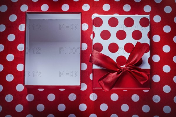Opened present box on polka-dot red fabric celebrations concept