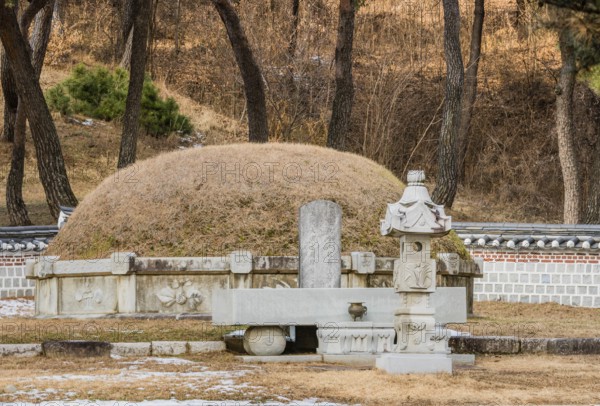 Chungju, South Korea, December 18, 2018: Burial mound surrounded by concrete wall and small statues