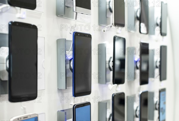 Smartphones on shelf in the store. Concept for communications and technology. Buying mobile phone in technology shop