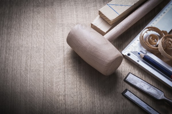 Wooden bricks mallet curled up scobs chisels try square pencil on wood board construction concept