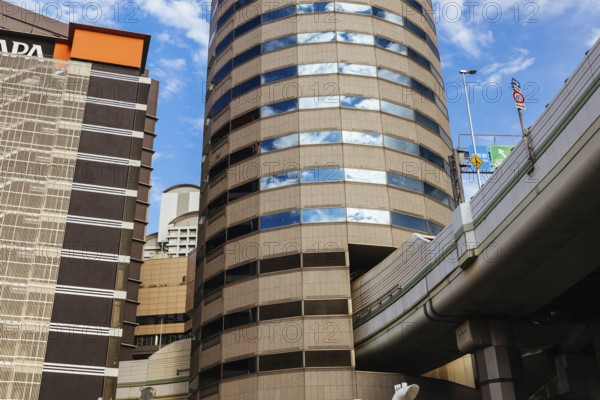 OSAKA, JAPAN - SEPTEMBER 25 2024: The famous 'highway thru a building'. The off ramp for the Umeda Exit of the Ikeda Route of the Hanshin Expressway going thru the Gate Tower Building in Downtown Osaka, Japan