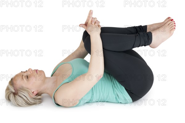 On the back of this young woman in the sport dress covers your knees with your hands with closed eyes on a white background
