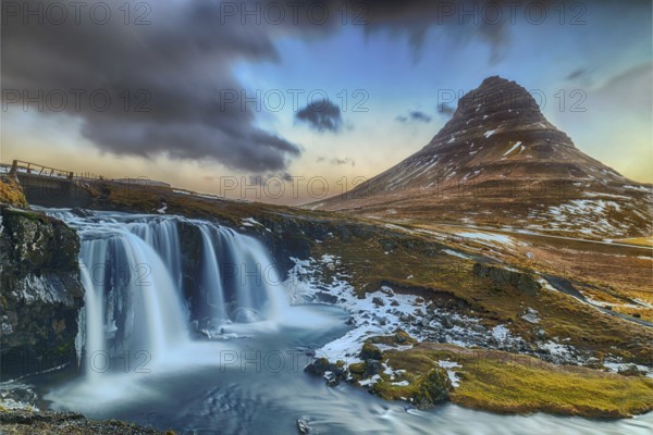 Famous waterfall under the conical mountain Kirkjufellsfoss