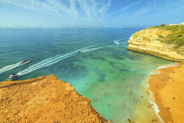 Aerial view of golden cliffs of Praia de Benagil in Algarve near Lagoa, Portugal, Europe. Boat trips to visit the famous landmark Algar de Benagil, the cave near Benagil Beach. Tourism in Algarve, Lagoa, Portogallo