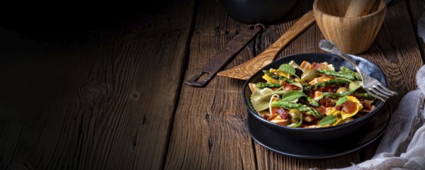 Pasta salad with green asparagus, olives and Parma ham