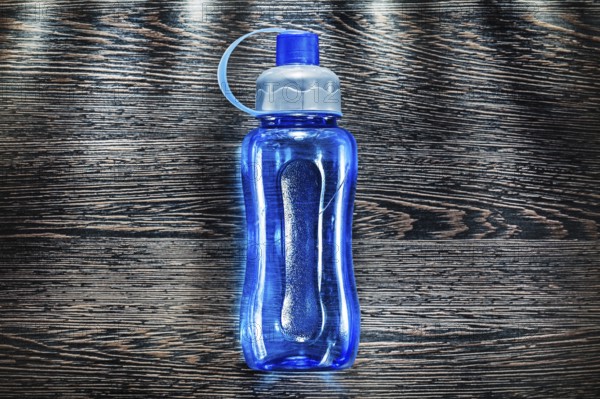 Plastic water shaker on vintage wooden board