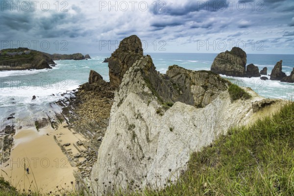 Cantabria. Noon on the beach of Playa di Arnia, Spain. Windy stormy day on the Atlantic coast. Rocky picturesque ocean coast. Powerful surf waves with a foam crest