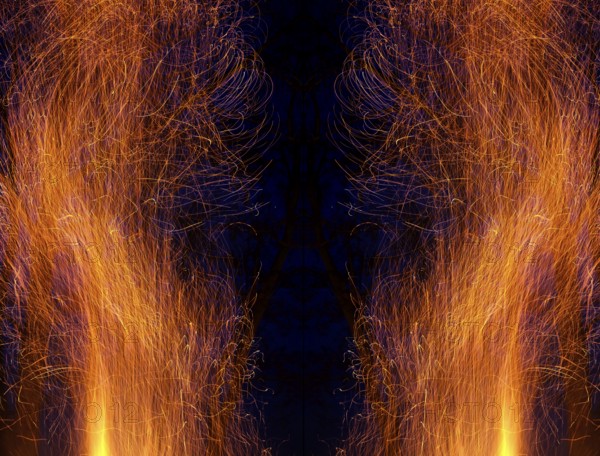Flying sparks as abstract imression with symmetrical composition in front of a blue-black background. Landscape format. Flying sparks as an abstract impression with symmetrical image composition against a black background. Horizontal format
