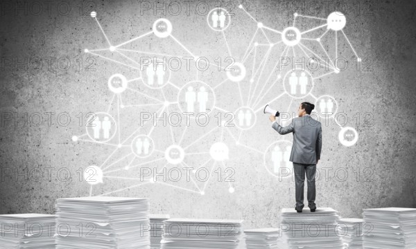 Businessman with speaker in hand standing on pile of documents with social network structure on background. Mixed media
