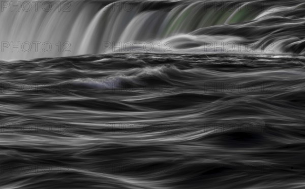 Abstract image of a dynamic, Horseshoe Falls of Niagara Falls in black and white with swirling water as seen from Niagara Falls, Ontario, Canada, North America