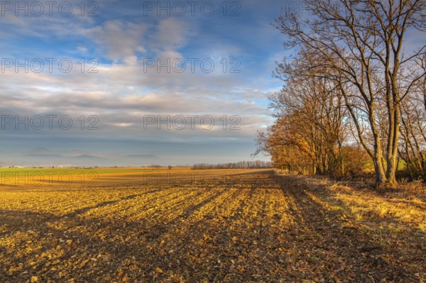 Autumn morning landscape over the city of Louny. Autumn plowed field at amazing sunrise. Czech Republic
