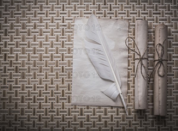 Rolls of vintage paper clean sheet quill on wicker mat