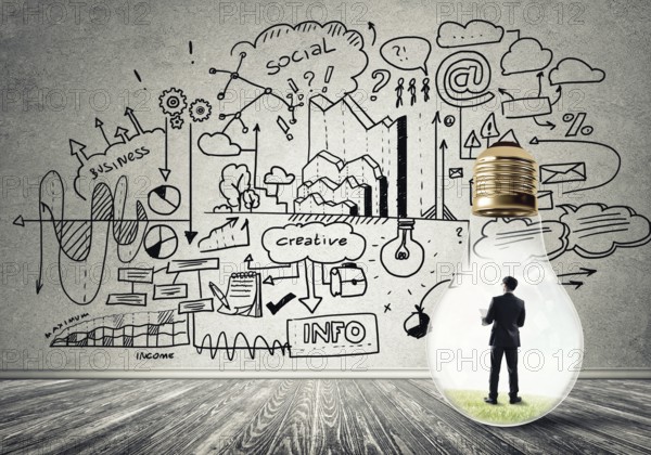 Businessman inside of light bulb in empty concrete room and sketches on wall