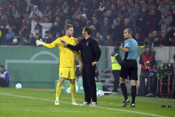 During a stoppage in play, head coach / coach Julian Schuster (SC Freiburg) gives instructions to goalkeeper Florian Müller (SC Freiburg) during the match for the DFB Cup 2024-25, 2nd round: SC Freiburg vs Hamburger SV, Freiburg im Breisgau, Germany / Germany