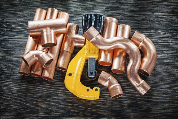 Plumbing copper water pipe cutter on wooden board