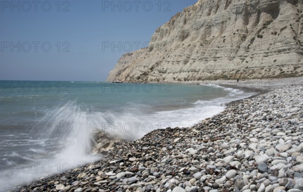 Empty pebble tropical beach under white cliffs against blue sky. Pissouri coastline Limassol Cyprus Europe