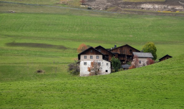 Traditional wooden cottage mountain houses in the green field in the dolomites. Housing in costadedoi Italian apls. Alpine region