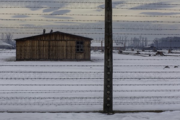 A view of the outside fence at the camp in Birkenau with winter snow on the ground. Birkenau, Poland